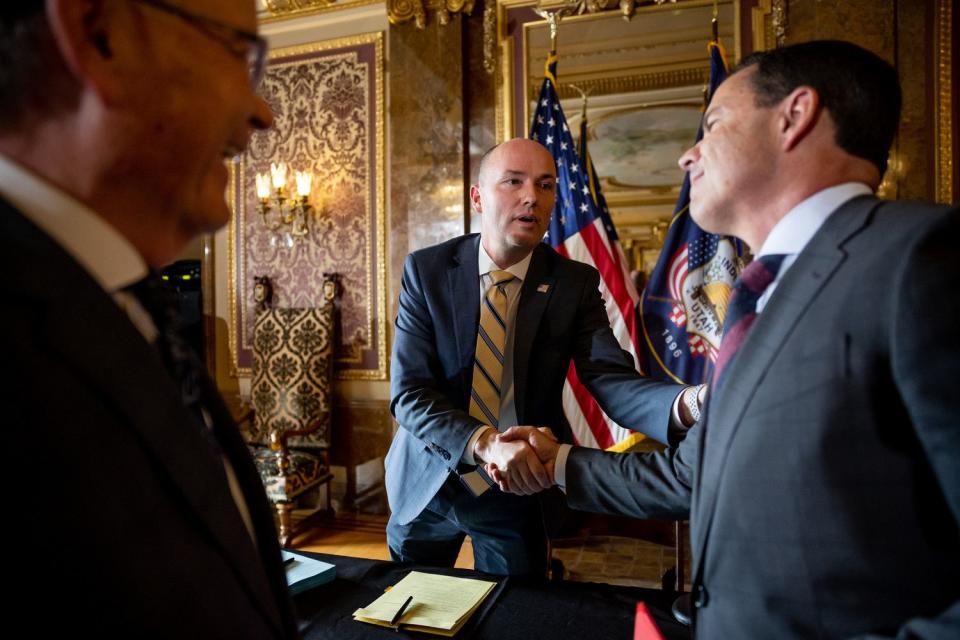 Gov. Spencer Cox chats with Senate President Stuart Adams, R-Layton, left, and House Speaker Brad Wilson, R-Kaysville, after Cox signed a series of tax bills into law at the Capitol in Salt Lake City on Wednesday.