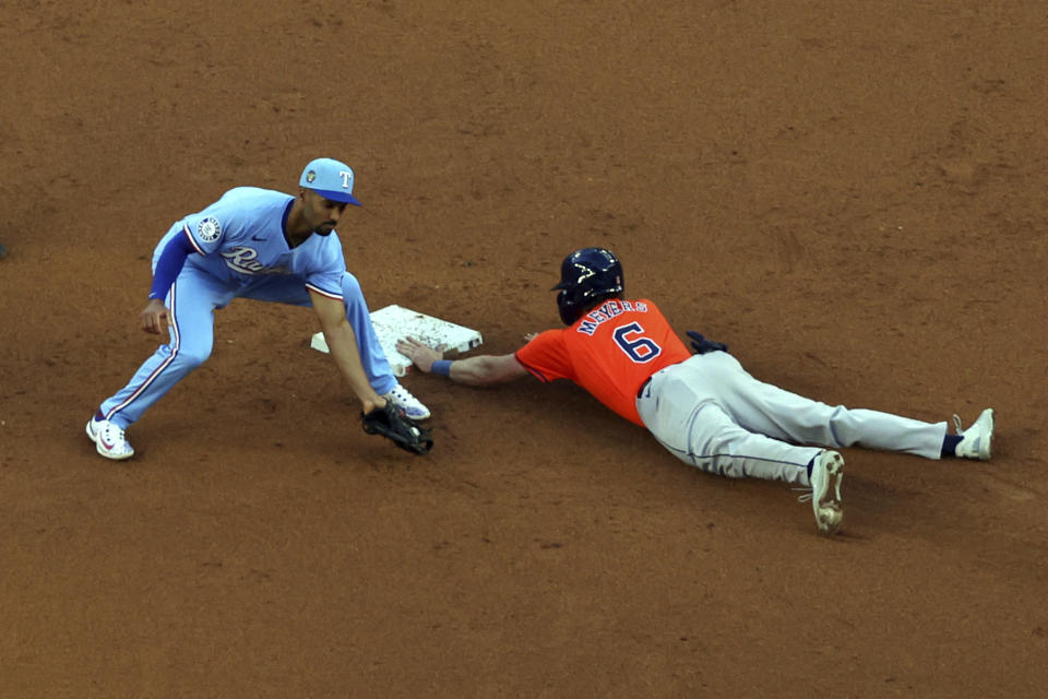 Texas Rangers second baseman Marcus Semien, left, gets the throw late as Houston Astros' Jake Meyers (6) steals the base in the third inning of a baseball game Sunday, April 7, 2024, in Arlington, Texas. (AP Photo/ Richard W. Rodriguez)