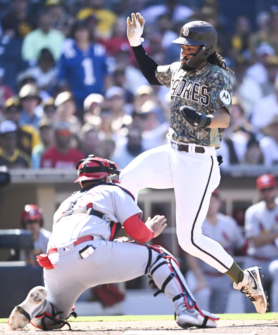 San Diego Padres' Fernando Tatis Jr. is tagged out at the plate by St. Louis Cardinals catcher Ivan Herrera during the fourth inning of a baseball game, Sunday, Sept. 24, 2023, in San Diego. (AP Photo/Denis Poroy)