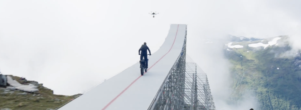 The stunt required Cruise to drive a motorcycle up a long ramp, which lead to a cliff, launch off of it and base jump to the bottom. He did it six times in one day. / Credit: Tom Cruise