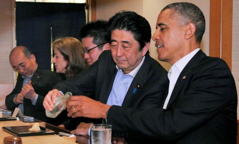 Shinzo Abe pours sake for Barack Obama as they have dinner at the Sukiyabashi Jiro sushi restaurant in Tokyo, in 2014.