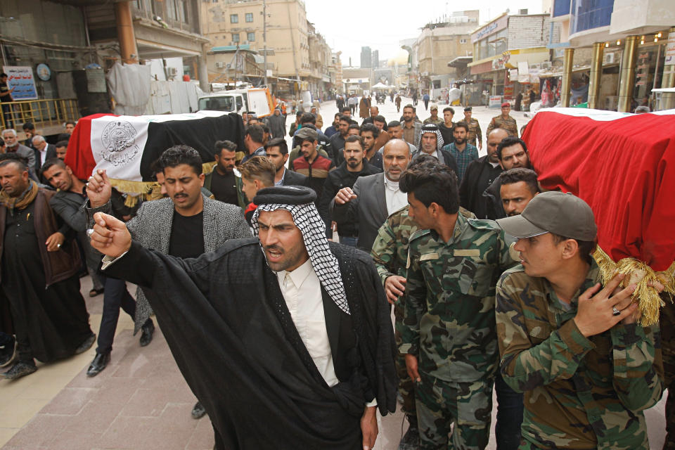 Mourners carry the flag-draped coffins of two fighters of the Popular Mobilization Forces who were killed during the US attack on against militants in Iraq, during their funeral procession at the Imam Ali shrine in Najaf, Iraq, Saturday, March 14, 2020. The U.S. launched airstrikes on Thursday in Iraq, targeting the Iranian-backed Shiite militia members believed responsible for a rocket attack that killed and wounded American and British troops at a base north of Baghdad. (AP Photo/Anmar Khalil)