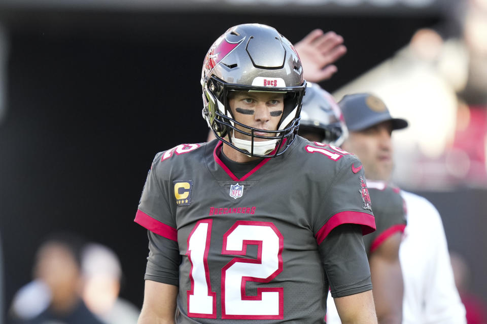 FILE - Tampa Bay Buccaneers quarterback Tom Brady (12) warms up before an NFL football game against the Cincinnati Bengals on Sunday, Dec. 18, 2022, in Tampa, Fla. Hardly a day passed in 2022 when a headline running across the ticker on ESPN would have been fitting on CNN or Fox Business. The intersection between sports and real life ranged from toxic workplace environments, alleged sexual misconduct, sportswashing, cryptocurrency, transgender sports and the COVID-19 pandemic. (AP Photo/Peter Joneleit, File)