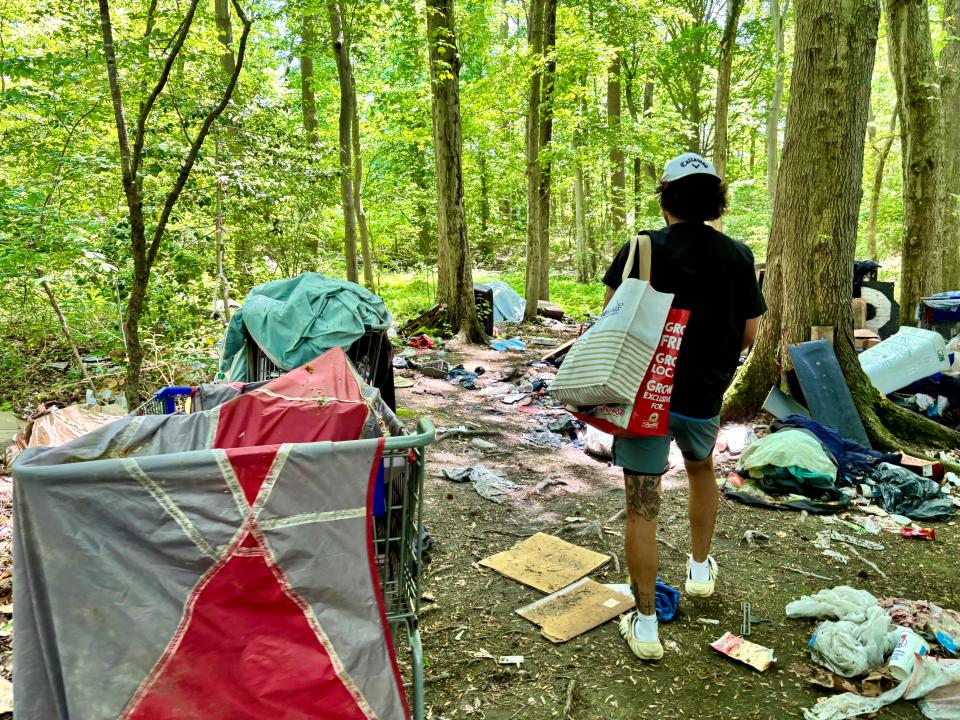 An outreach worker walks through a homeless encampment in Dover.