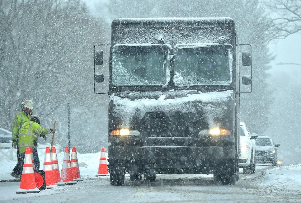 A UPS truck makes its way down a snowy street during a winter storm.