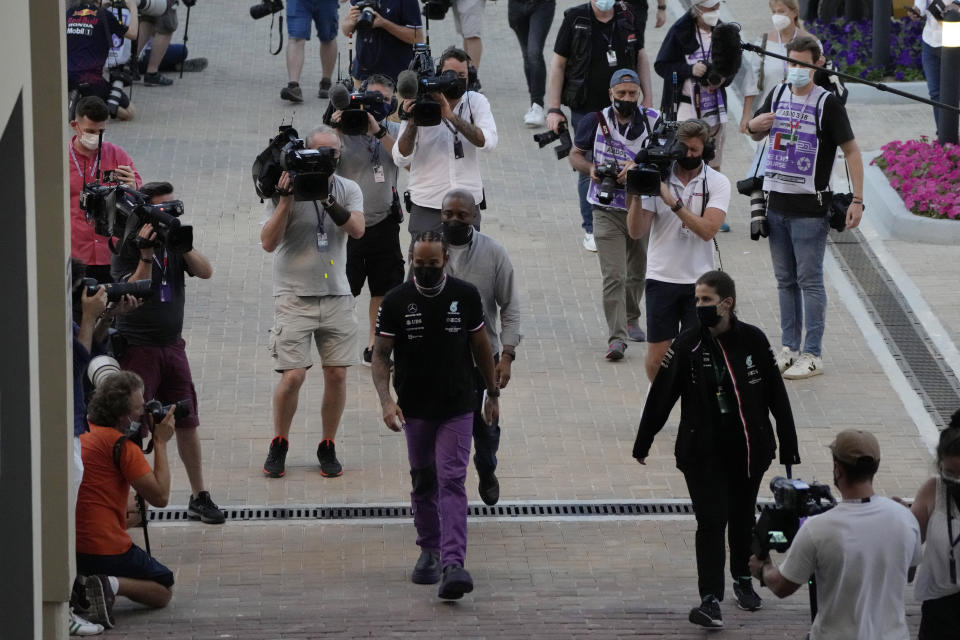 Mercedes driver Lewis Hamilton of Britain arrives for his press conference with Red Bull driver Max Verstappen of the Netherlands at the Yas Marina racetrack in Abu Dhabi, United Arab Emirates, Thursday, Dec. 9, 2021. (AP Photo/Hassan Ammar)