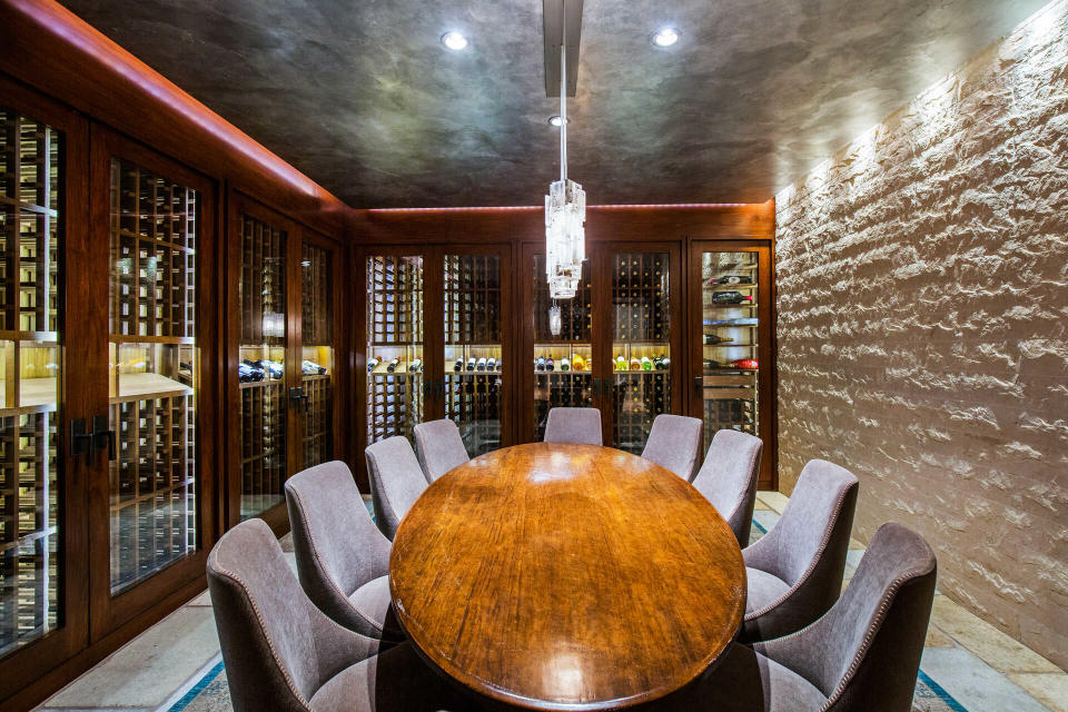 Other amenities in the house include a game room, a bar, an office, a gym, a media room, staff quarters, and this wine storage and tasting room.