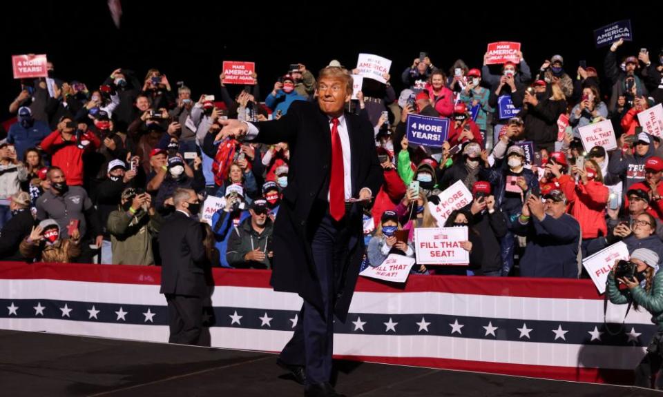 Donald Trump throws face masks to the crowd as he arrives to hold a campaign rally in Johnstown, Pennsylvania.