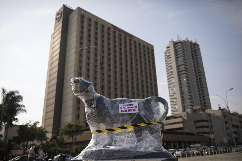 A sculpture of a lioness outside the Palace of Justice is wrapped in plastic in Lima, Peru, Saturday, Nov. 21, 2020. Monuments were practically spared, in part because they were protected with plastic or fabrics, but also because they were not the aim of protesters as they filled the streets, decrying a parliamentary coup in early November when Congress voted to oust ex-President Martín Vizcarra. (AP Photo/Rodrigo Abd)