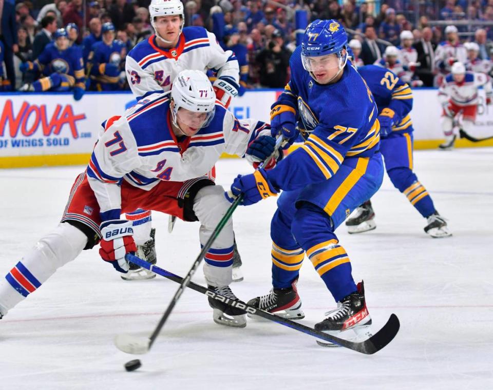 Mar 31, 2023; Buffalo, New York, USA; Buffalo Sabres right wing JJ Peterka (77) and New York Rangers defenseman Niko Mikkola (77) battle for the puck in the second period at KeyBank Center. Mandatory Credit: Mark Konezny-USA TODAY Sports