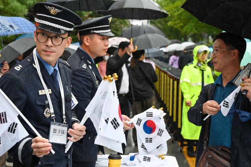 South Korean Air Force personnel hand out flags at the Armed Forces Day parade in Seoul on Tuesday. Photo by Thomas Maresca/UPI