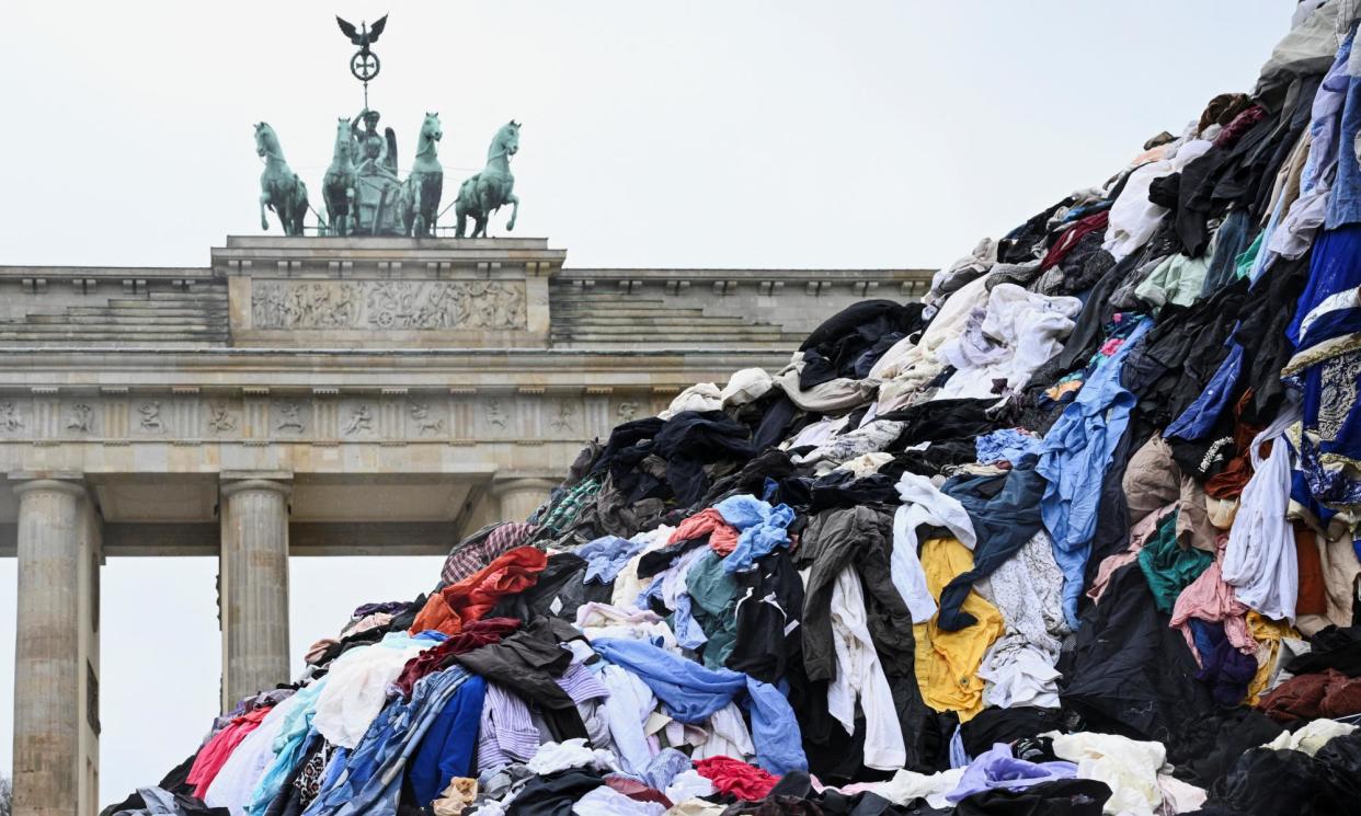 <span>A protest against fast fashion in Berlin, with ‘a mountain’ of textile waste from a second-hand market in Ghana.</span><span>Photograph: Annegret Hilse/Reuters</span>