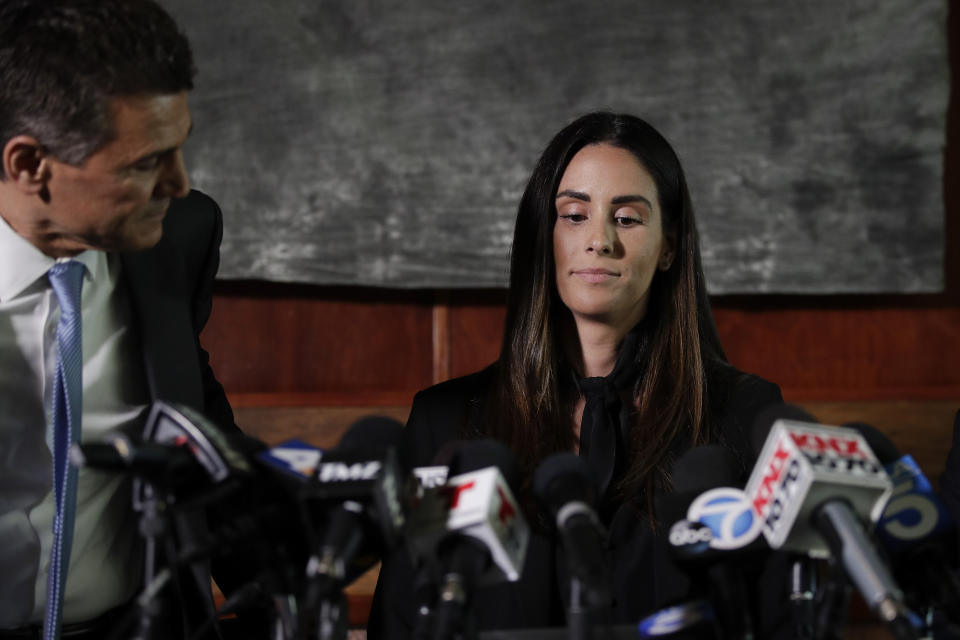 Attorney Garo Mardirossian, left, pats the back of former sports reporter Kelli Tennant before the start of a news conference, Tuesday, April 23, 2019, in Los Angeles. Tennant filed the suit in Los Angeles County Superior Court on Monday, contending new Sacramento Kings NBA basketball coach Luke Walton assaulted her in a hotel room in Santa Monica while he was an assistant coach for the Golden State Warriors. (AP Photo/Jae C. Hong)