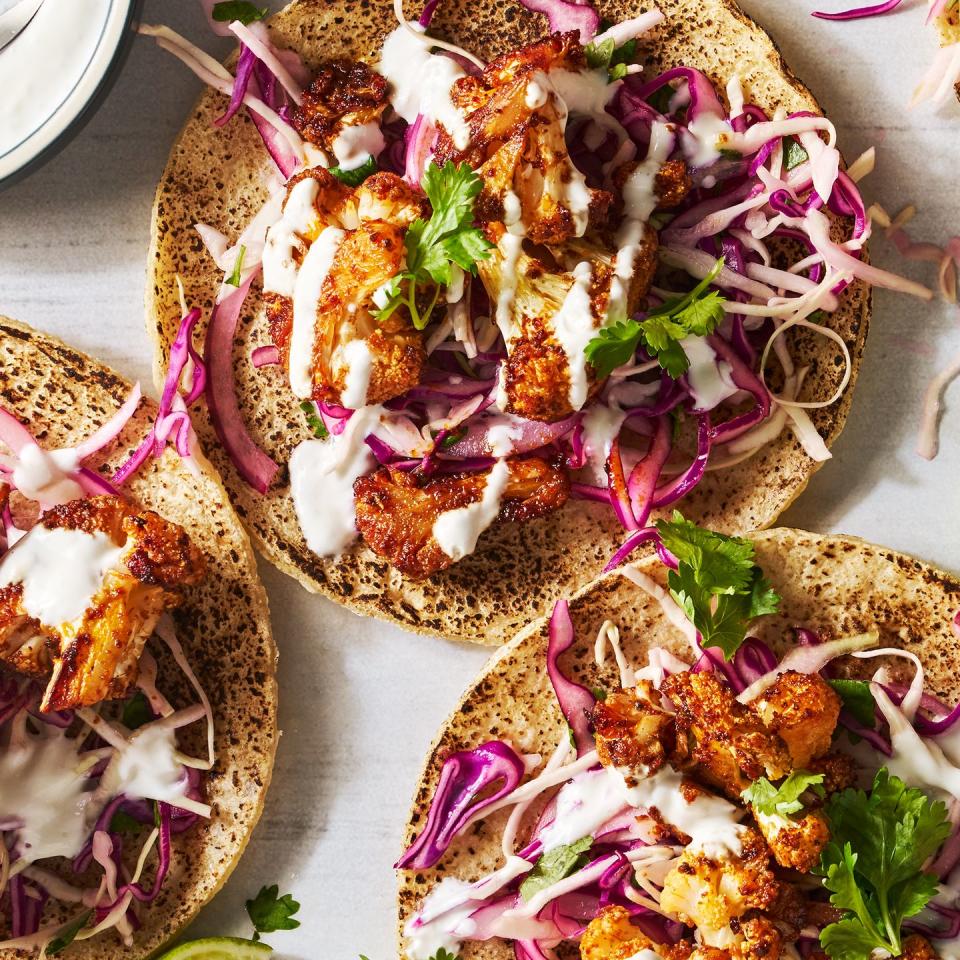 cauliflower tacos topped with cabbage, cilantro, and sour cream sauce