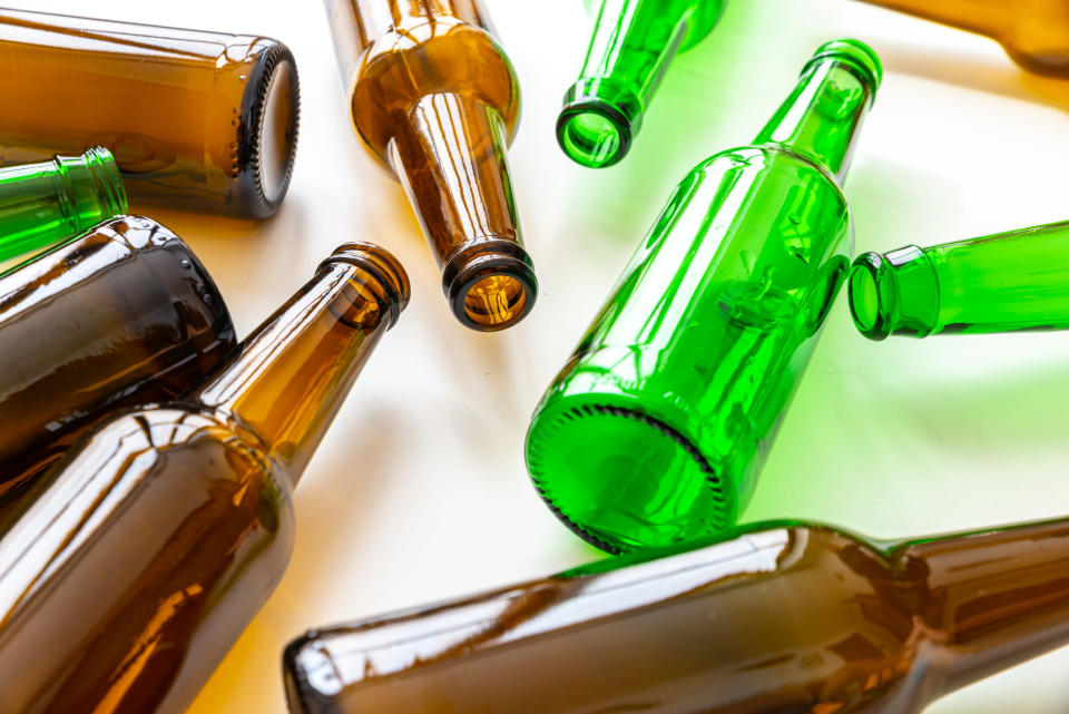 Empty green and brown glass bottles scattered on a surface