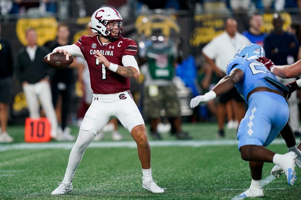 South Carolina quarterback Spencer Rattler, left, throws the ball during the first half of an NCAA college football game against North Carolina, Saturday, Sept. 2, 2023, in Charlotte, N.C. (AP Photo/Erik Verduzco)