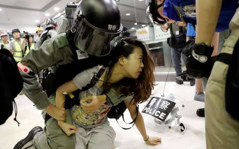 A woman is detained by riot police at a shopping mall in Tai Po in Hong Kong,  - Credit: &nbsp;KIM KYUNG-HOON/&nbsp;REUTERS