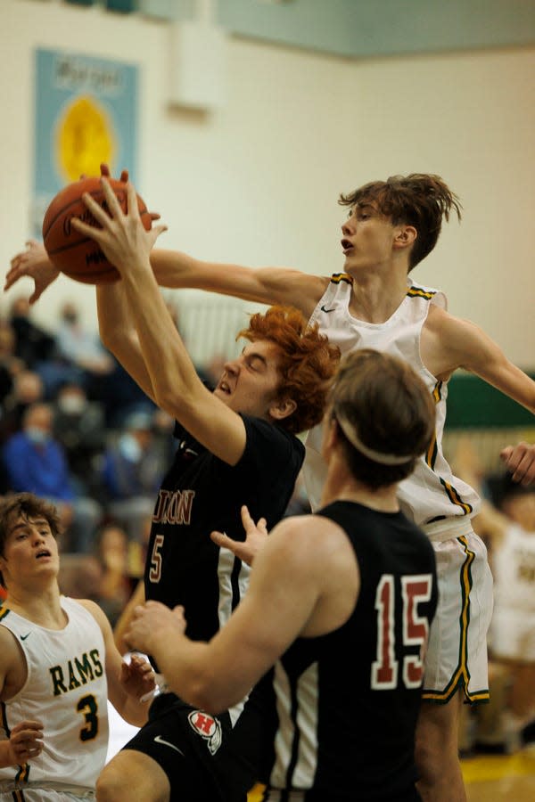 New Boston Huron's Chad Martin (center) fights for a rebound with Tim Murphy of Flat Rock during a 68-55 Flat Rock win Friday night.