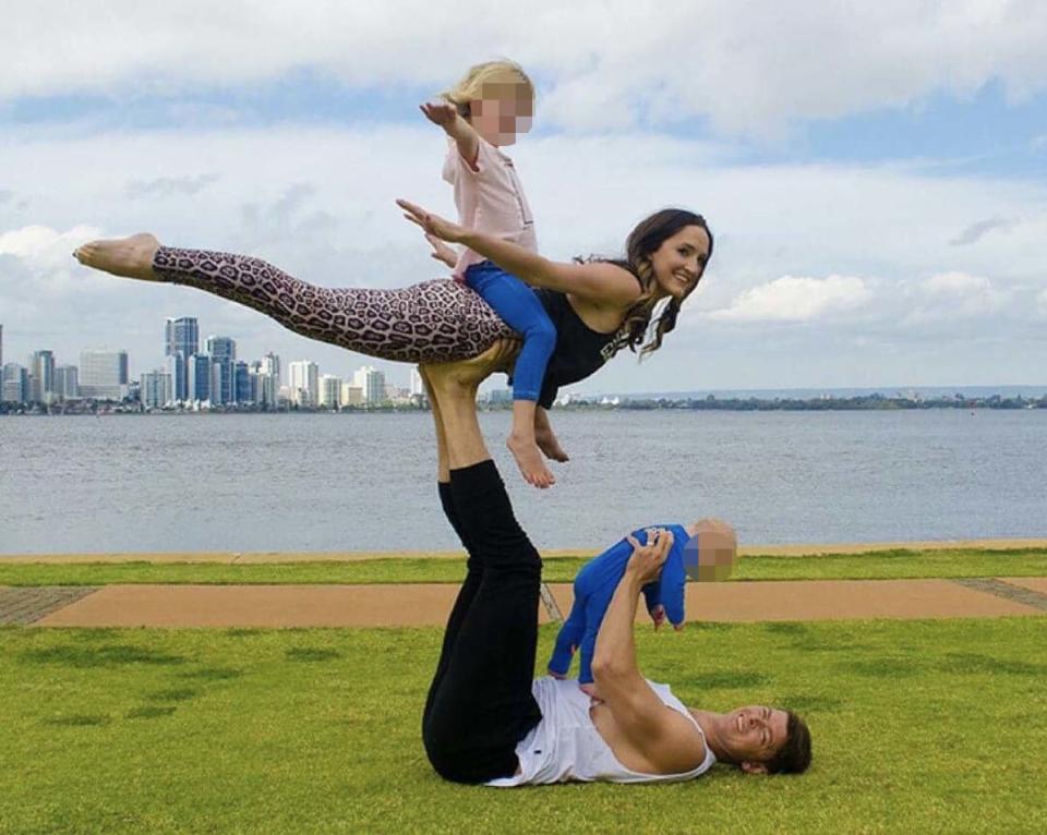 The young family acrobatically posing for a photo near a body of water.