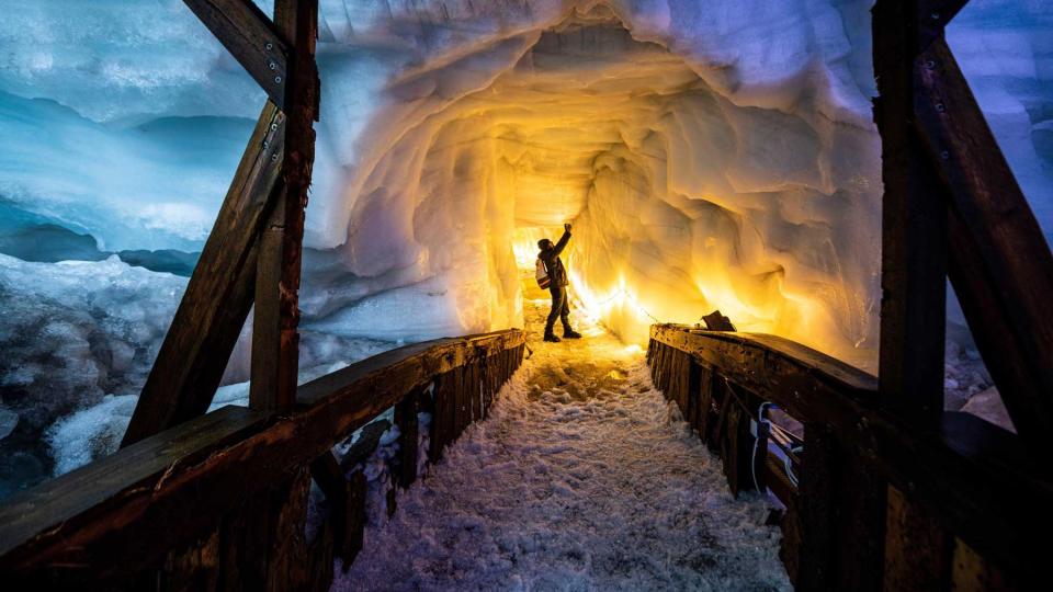 A man stands on a lighted walkway at the Langjokull glacier in Iceland