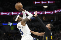 Minnesota Timberwolves forward Jaden McDaniels (3) shoots while defended by Golden State Warriors guard Stephen Curry during the first half of an NBA basketball game, Wednesday, Feb. 1, 2023, in Minneapolis. (AP Photo/Abbie Parr)