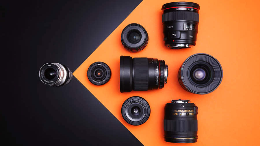  A selection of wide-angle prime lenses on an orange and black background. 