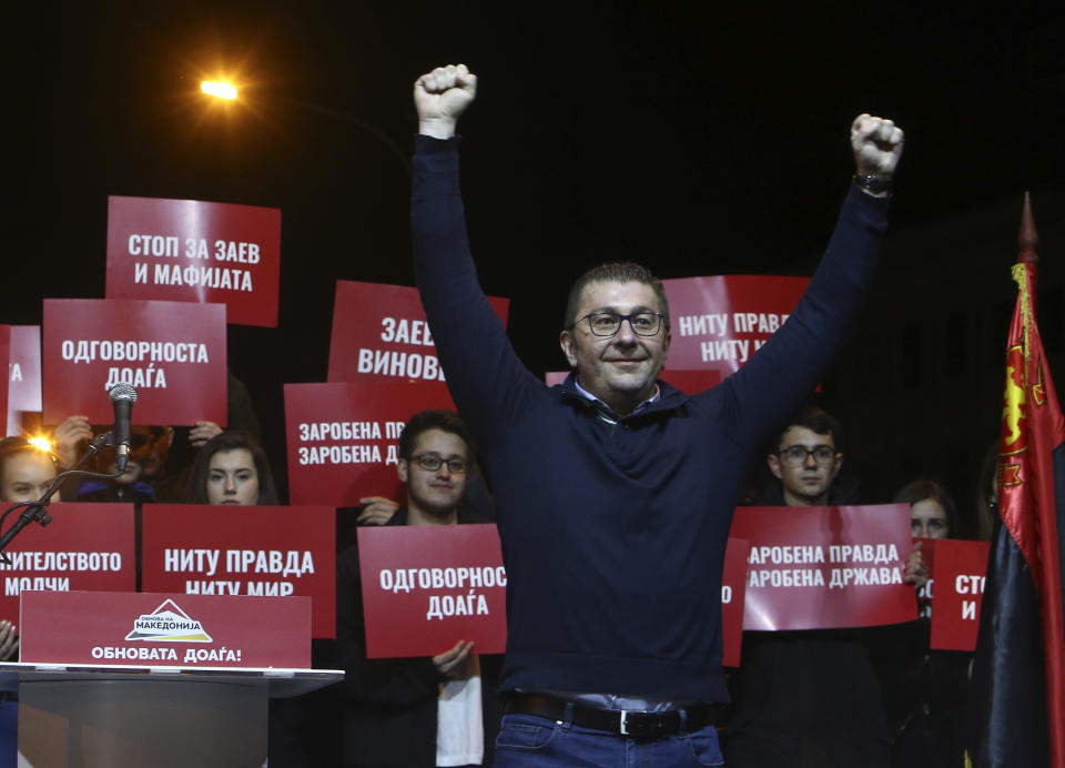 Hristijan Mickoski, leader of the opposition conservative VMRO-DPMNE party, is raising his fists during a protest in front of the complex of national courts, in Skopje, North Macedonia, Tuesday, Feb. 25, 2020. Thousands of conservative opposition party supporters were marching in North Macedonia's capital Skopje late on Tuesday, accusing the outgoing leftist government for strongly influencing prosecution and court decisions. (AP Photo/Boris Grdanoski)