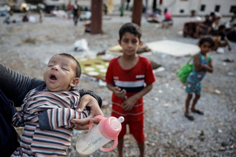 A mother holds her infant as two young children watch on in the Lebanese capital of Beirut (REUTERS)