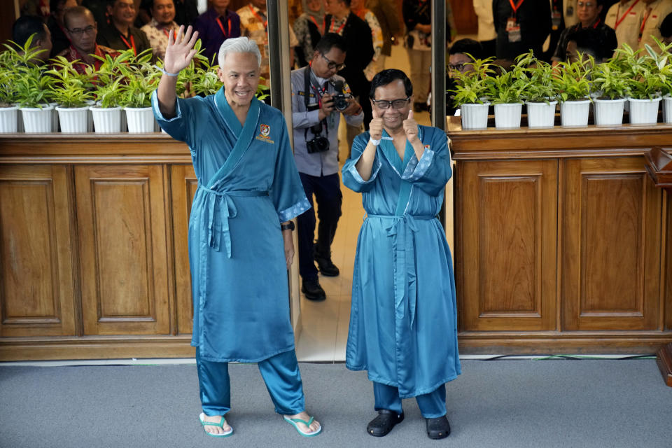 Presidential candidate Ganjar Pranowo, left, and his running mate Mohamad Mahfud, popularly known as Mahfud MD, greet reporters prior to the medical check up required for their candidacy in the upcoming presidential election, at Gatot Subroto Army Hospital in Jakarta, Indonesia, Sunday, Oct. 22, 2023. The world's third-largest democracy is holding its legislative and presidential elections on Feb. 14, 2024. (AP Photo/Dita Alangkara)