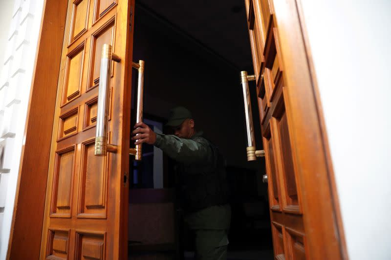 A member of the Bolivarian National Guard opens the door of presidency office at Venezuela's National Assembly building in Caracas