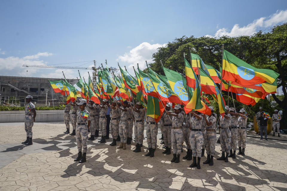 Members of the Ethiopian National Defense Force hold national flags as they parade during a ceremony to remember those soldiers who died on the first day of the Tigray conflict, outside the city administration office in Addis Ababa, Ethiopia Thursday, Nov. 3, 2022. Ethiopia's warring sides agreed Wednesday to a permanent cessation of hostilities in a conflict believed to have killed hundreds of thousands, but enormous challenges lie ahead, including getting all parties to lay down arms or withdraw. (AP Photo)