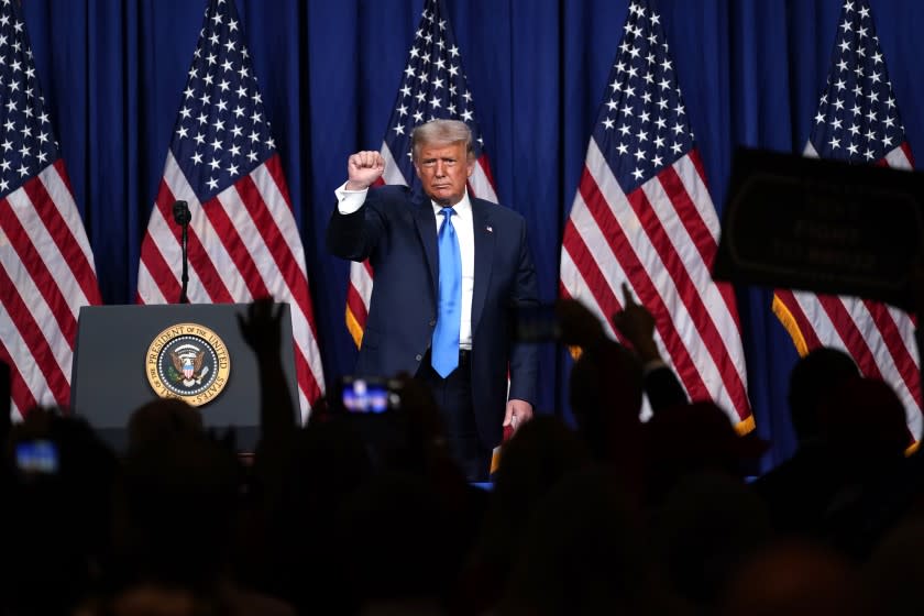 President Donald Trump stands on stage after speaking during the first day of the Republican National Committee convention.