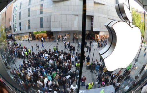 Customers queue to enter the Apple Store in the southern German city of Munich