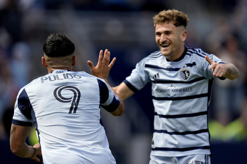 Sporting Kansas City forward Alán Pulido (9) celebrates with midfielder Marinos Tzionis after scoring a goal during the second half of an MLS soccer match against the Portland Timbers Sunday, May 28, 2023, in Kansas City, Kan. Sporting Kansas City won 4-1. (AP Photo/Charlie Riedel)