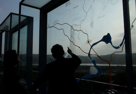 Visitors look at a map showing the demilitarized zone separating the two Koreas at Imjingak pavilion, near the truce village of Panmunjom in Paju, South Korea May 10, 2018. REUTERS/Kwak Sung-Kyung/Files