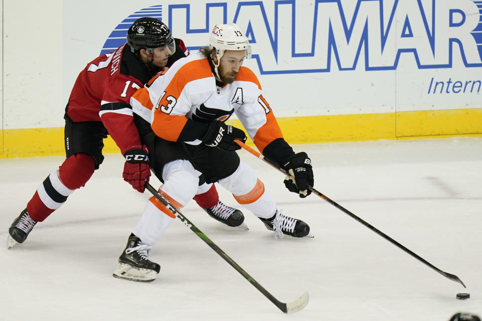 New Jersey Devils' Yegor Sharangovich (17) fights for control of the puck with Philadelphia Flyers' Kevin Hayes (13) during the first period of an NHL hockey game Tuesday, Jan. 26, 2021, in Newark, N.J. (AP Photo/Frank Franklin II)