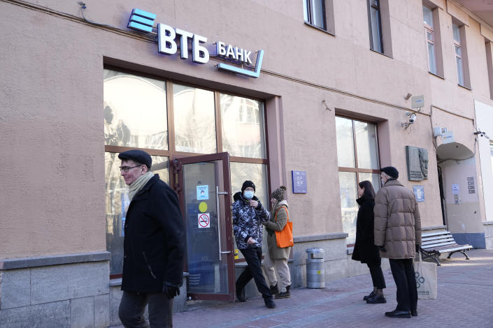 People stand in line to withdraw money from an ATM of VTB Bank in downtown Moscow, Russia, Monday, Feb. 28, 2022. Ordinary Russians faced the prospect of higher prices and crimped foreign travel as Western sanctions over the invasion of Ukraine sent the ruble plummeting, leading uneasy people to line up at banks and ATMs on Monday in a country that has seen more than one currency disaster in the post-Soviet era. (AP Photo/Pavel Golovkin)