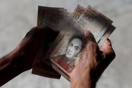 Los venezolanos necesitan tener grandes cantidades de billetes para pagar un refresco o un café. (REUTERS/Marco Bello)