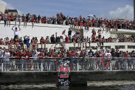 Fans watch the Tampa Bay Buccaneers celebrate their Super Bowl 55 victory over the Kansas City Chiefs with a boat parade in Tampa, Fla., Wednesday, Feb. 10, 2021. (AP Photo/Phelan Ebenhack)