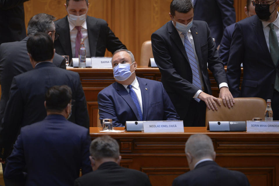 Romanian Prime Minister designate Nicolae Ciuca wears a mask before a parliament vote on his government team in Bucharest, Romania, Thursday, Nov. 25, 2021. Romanian lawmakers voted in favor of a new coalition government led by a Liberal former army general, which could usher in an end to a months-long political crisis in the Eastern European nation. (AP Photo/Alexandru Dobre)