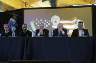 From left to right, Megan Rapinoe, a forward with the National Women's Soccer League's Reign FC and the U.S. Women's National Team, former NBA basketball star Tony Parker, OL Groupe's Gerard Houllier, Jean-Michel Aulas, owner and president of the French soccer team Olympique Lyonnais, and Bill Predmore, former owner of the National Women's Soccer League Reign FC team, watch a video presentation, Thursday, Dec. 19, 2019, during a news conference in Tacoma, Wash. OL Groupe, the parent company of Olympique Lyonnais, is buying Reign FC, of the in a transaction expected to close in January 2020. Reign FC will continue to play its home games at Cheney Stadium, the venue it shares with the Triple-A minor league baseball team the Tacoma Rainiers. (AP Photo/Ted S. Warren)