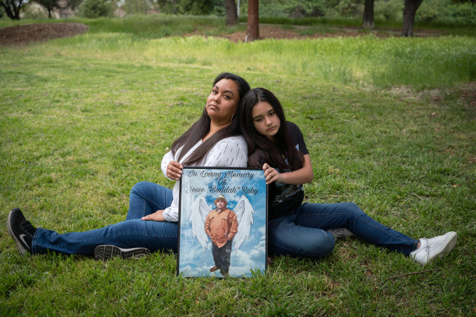 Virginia Herrera y su hija Ginger, de 12 años, con una imagen para recordar a Jesse Ruby, quien falleció en enero debido a la COVID-19 a la edad de 38 años, en San José, California, el 3 de abril de 2021. (Sarahbeth Maney/The New York Times)