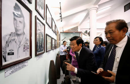 Former Vietnamese President Truong Tan Sang (C) and Deputy Prime Minister Truong Hoa Binh (R) looks at the images of U.S. soldiers who fired the villagers 50 years ago while they visit the museum during the 50th anniversary of the My Lai massacre in My Lai village, Vietnam March 16, 2018. REUTERS/Kham