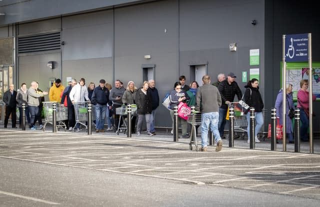 Shoppers queue outside an Asda Superstore at Straiton, Edinburgh 