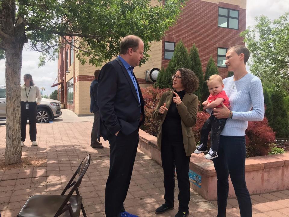 Colorado Gov. Jared Polis speaks with Colorado House Majority Leader Daneya Esgar, left, and Heather Palm, right, holding their daugter, Marlo, on Monday, May 23, 2022, in Pueblo, Colorado.