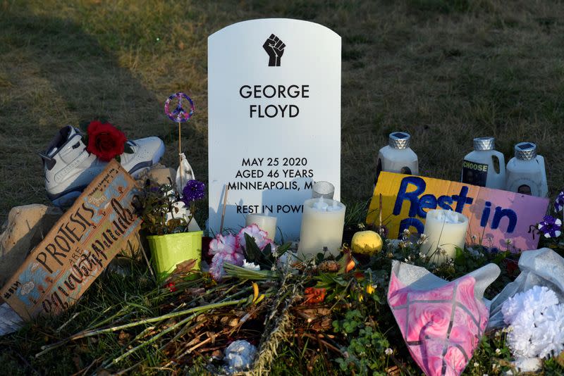 A memorial to George Floyd is lit by morning light one month later in Minneapolis