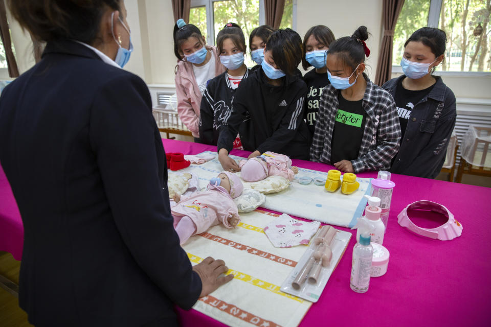 An instructor teaches Uyghurs how to change a diaper during a class at the Peyzawat Training School in Peyzawat County in China's far west Xinjiang region, as seen during a state-organized tour for foreign media on April 19, 2021. Four years after Beijing's brutal crackdown on largely Muslim minorities native to Xinjiang, Chinese authorities are dialing back the region's high-tech police state and stepping up tourism. But even as a sense of normality returns, fear remains, hidden but pervasive. (AP Photo/Mark Schiefelbein)