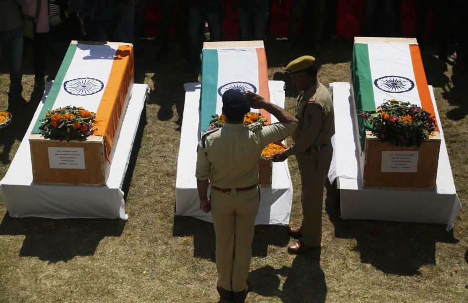 An Indian police officer pays his respects to fallen colleagues at a base camp at shopian, about 63 kilometers south of Srinagar, Indian controlled Kashmir, Friday, Sept. 21, 2018. Anti-India rebels in disputed Kashmir raided over a dozen homes of police officers and abducted three whose bullet-riddled were recovered Friday, officials said. The killings came days after the region's largest rebel group asked officers to quit the Kashmiri police force and stay away from counterinsurgency operations. (AP Photo/Mukhtar Khan)