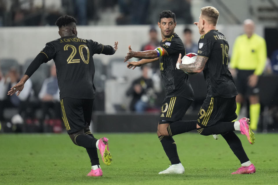 Los Angeles FC forward Carlos Vela, center, celebrates with midfielder José Cifuentes (20) and midfielder Mateusz Bogusz (19) after scoring during the second half of an MLS soccer match against the Vancouver Whitecaps in Los Angeles, Saturday, June 24, 2023. (AP Photo/Ashley Landis)