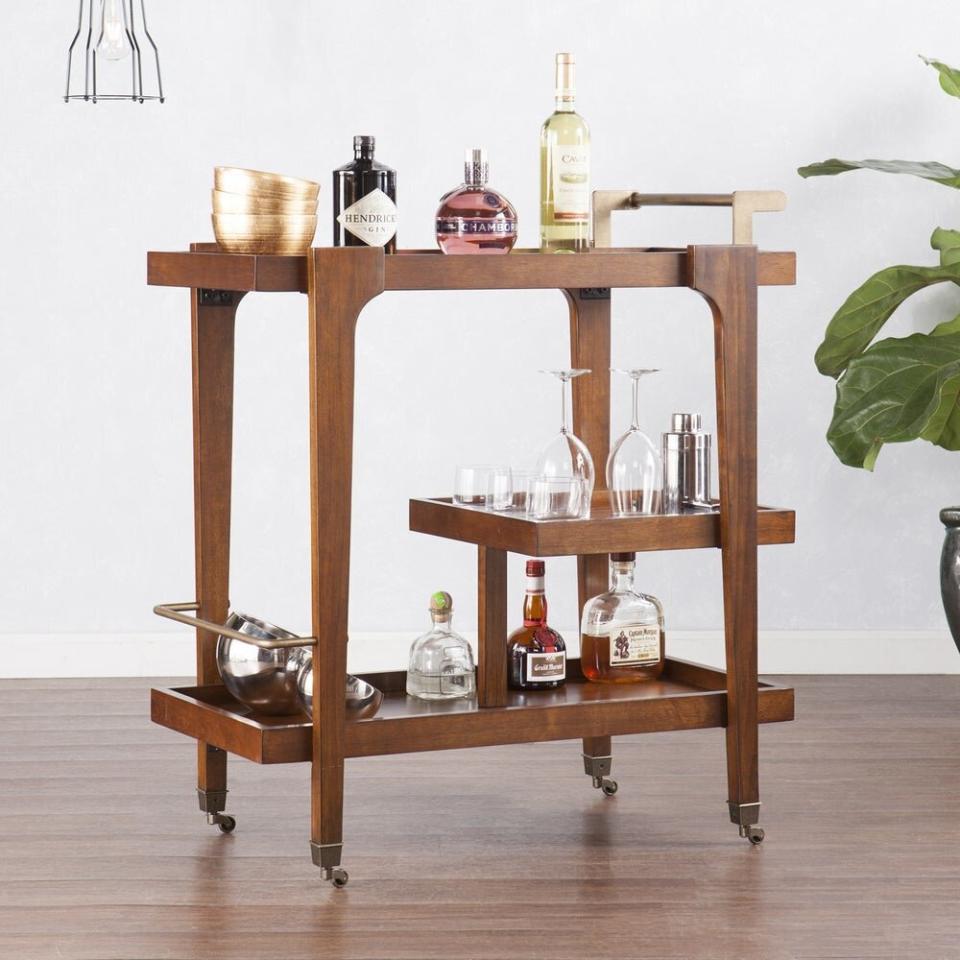 This mid-century modern bar cart's as classy as they come. It has three-tiers with a bottom shelf that has guardrails to protect your beloved bottles and a handle so it's easy to roll around. It comes in black, white and brown so you can match it to your furniture. Your next party is sure to be a hit. <a href="https://fave.co/37b5WOi" target="_blank" rel="noopener noreferrer"><strong>Originally&nbsp;$250, get it for $156 at Overstock</strong></a>.